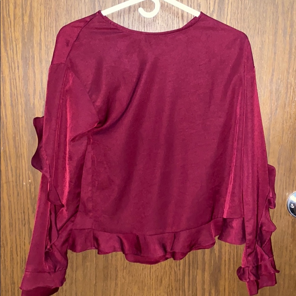 Burgundy ruffled blouse.